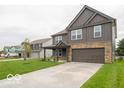 Two-story home with gray siding, stone accents, covered porch, and two-car garage at 7517 Big Bend Blvd, Camby, IN 46113