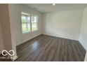 Bright living room showcases wood-look flooring and a large window, perfect for modern living at 7517 Big Bend Blvd, Camby, IN 46113