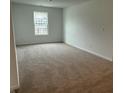 An empty carpeted bedroom with one window and white walls shows spacious potential at 7605 Big Bend Blvd, Camby, IN 46113