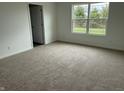 A bright carpeted bedroom featuring a large window with a view of trees at 7605 Big Bend Blvd, Camby, IN 46113