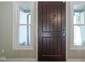 Close up of the dark wood front door with sidelight windows and neutral colored walls at 858 Cedar Wood, Carmel, IN 46032