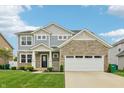 Charming two-story home with a stone facade, a two-car garage, and lush green landscaping at 951 Parker Ln, Westfield, IN 46074
