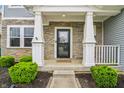 Inviting front porch with stone accents, white pillars, and manicured shrubs at 951 Parker Ln, Westfield, IN 46074