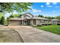 Attractive home boasts a paved driveway, attached garage, and well-maintained landscaping at 10036 E Troy Ave, Indianapolis, IN 46239