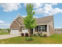 Charming brick home featuring a large three car garage, front porch, and landscaped yard at 1270 Shaw Ln, Shelbyville, IN 46176