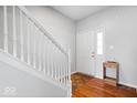 Inviting foyer with hardwood floors, a staircase with white railing, and a bright white front door at 12832 Broncos Dr, Fishers, IN 46037