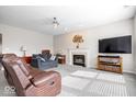 Cozy living room with a fireplace, plush carpeting, and comfortable seating for relaxing and entertaining at 12832 Broncos Dr, Fishers, IN 46037