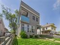 Contemporary two-story home with a small balcony and fenced-in yard, blending modern design with cozy curb appeal at 1409 Spann Ave, Indianapolis, IN 46203