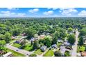 Expansive aerial view of a residential neighborhood with lush green trees and scattered homes under a blue sky at 1515 S Emerson Ave, Indianapolis, IN 46203