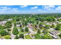 Scenic aerial view of a neighborhood with mature trees, well-maintained homes, and city skyline in the distance at 1515 S Emerson Ave, Indianapolis, IN 46203