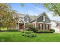 Charming two-story home with brick and gray siding, complemented by a well-maintained lawn and mature trees at 17002 Folly Brook Rd, Noblesville, IN 46060
