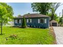 Beautiful single-story home on a well-manicured lawn with a detached garage and a driveway at 1747 S Irvington Ave, Indianapolis, IN 46203