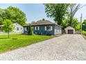Beautiful home with manicured lawn, gravel driveway and a detached garage at 1747 S Irvington Ave, Indianapolis, IN 46203