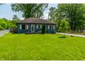 Charming one-story home with a well-maintained lawn, mature trees, and a gravel driveway at 1747 S Irvington Ave, Indianapolis, IN 46203