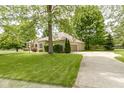 Wide view of the home's exterior and long driveway surrounded by lush trees at 1941 Orchard Ct, Carmel, IN 46280