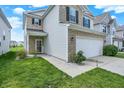 Well-manicured front yard with a two-story home featuring stone and siding, plus an attached two-car garage at 2473 Shadow Bend Dr, Columbus, IN 47201
