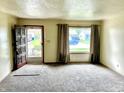 Cozy living room with neutral carpet, large window with natural light, and a view of the neighborhood at 3633 Tiffany Dr, Indianapolis, IN 46226