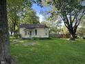 Quaint home with a large, well-maintained lawn and mature trees, offering shade and curb appeal at 404 Pearl St, Pendleton, IN 46064