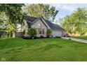 Lovely home with lush green lawn, mature trees, brick details, garage and an American flag in front at 410 Wood Hollow Ct, Westfield, IN 46074