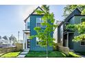 Stylish home showcasing a blue facade with a well-kept lawn and a charming, fenced yard at 43 N Walcott St, Indianapolis, IN 46201