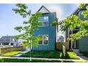 Contemporary home with a bright blue facade, enhanced by verdant landscaping and clear blue skies at 43 N Walcott St, Indianapolis, IN 46201