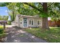 Cozy home featuring light gray siding, an inviting entryway, and a mature tree shading the property at 4809 Allisonville Rd, Indianapolis, IN 46205