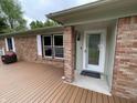 Welcoming front entrance with a decorative glass door, brick column, and wood porch at 5725 W 200 N, Lebanon, IN 46052