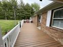 Spacious wooden front porch with white railings, offering an inviting outdoor living area with seating at 5725 W 200 N, Lebanon, IN 46052
