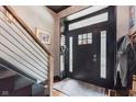 Modern foyer with a black door and sidelights, featuring a view of a staircase at 584 S 10Th St, Noblesville, IN 46060