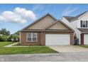 A brick and vinyl sided single Gathering home with an attached two-car garage, concrete driveway, and a front lawn at 608 Fisher Creek Dr, Indianapolis, IN 46239
