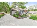 View of the home from the driveway surrounded by lush landscaping at 6110 Orinoco Ave, Indianapolis, IN 46227