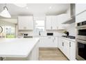 Modern kitchen with island, stainless appliances, white cabinets, and a window overlooking the yard at 6421 Springtide Ct, Plainfield, IN 46168