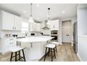 Bright kitchen featuring white cabinets, stainless steel appliances, and an island with pendant lighting at 6421 Springtide Ct, Plainfield, IN 46168