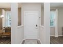 Modern entryway with white door, neutral walls, and view of the nearby living area at 6465 Wasco Dr, Whitestown, IN 46075