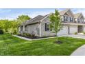Exterior view of new townhome with stone facade, large lawn, and landscaping at 6465 Wasco Dr, Whitestown, IN 46075
