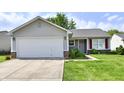 Attractive single-story home with a two-car garage, tidy landscaping, and a welcoming driveway at 6556 Wandering Way, Indianapolis, IN 46241