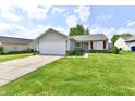 Inviting single-story home with a neat front lawn, attached garage, and quaint front entrance at 6556 Wandering Way, Indianapolis, IN 46241
