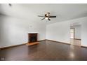 This living room has dark wood floors, a fireplace, and a ceiling fan at 6715 Wandering Way, Indianapolis, IN 46241