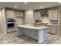 Modern kitchen features stainless steel appliances, gray cabinets, a spacious island and stylish countertops at 6833 Jacone Dr, Brownsburg, IN 46112