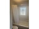 Bathroom with white marble tile, bathtub with shower, and glass block window at 732 W 700 N, Fortville, IN 46040
