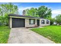 Stone facade home with an attached garage and a traditional lawn at 7625 E 35Th St, Indianapolis, IN 46226