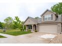 Charming exterior elevation with an attached garage and long driveway leading up to the home, with a front lawn at 808 Heartland Ln, Brownsburg, IN 46112