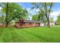 Well-manicured lawn highlights this charming single-story brick home with mature trees at 820 S Eaglewood Dr, Zionsville, IN 46077