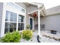 Inviting porch area with decorative plants, a table, and chairs, all complemented by manicured landscaping at 895 Geronimo Dr, Greenfield, IN 46140