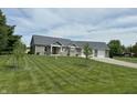 Charming brick home featuring an attached two-car garage and a well-manicured lawn at 951 N Maiellen Dr, Greenfield, IN 46140
