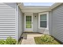 Close-up of the light grey home featuring a storm door and nice landscaping at 9560 W Campfire Dr, Pendleton, IN 46064