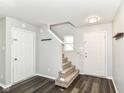 Bright entryway with wood-look floors, white doors, carpeted stairs, and a coat rack at 9676 W Constellation Dr, Pendleton, IN 46064
