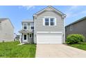 Inviting two-story home featuring a two-car garage, neat landscaping, and light gray siding at 9676 W Constellation Dr, Pendleton, IN 46064