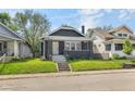 Charming home with a well-manicured lawn, gray siding, inviting front porch, and steps at 1016 Churchman Ave, Indianapolis, IN 46203
