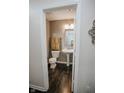 Cozy half-bathroom features a pedestal sink and dark wood-look flooring at 10447 Pintail Ln, Indianapolis, IN 46239